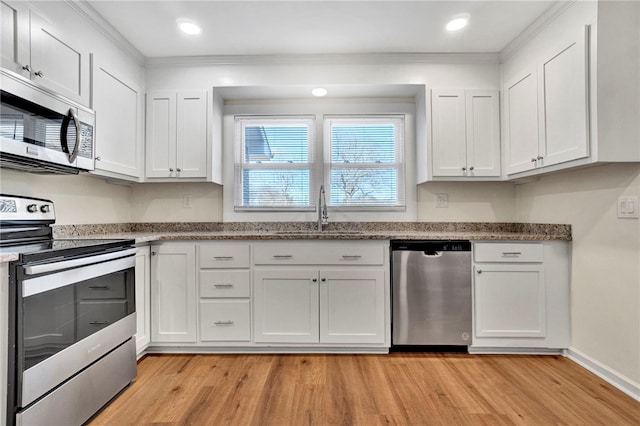 kitchen featuring a sink, light wood-style flooring, white cabinetry, and stainless steel appliances