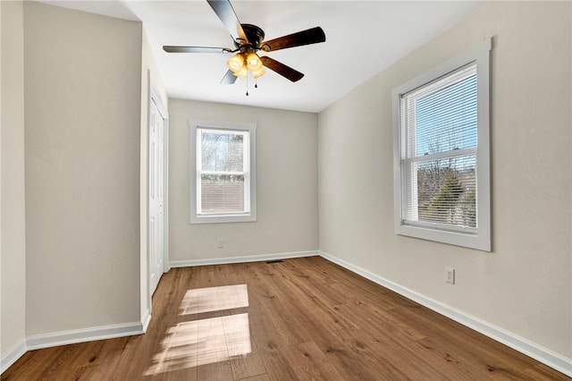 unfurnished room featuring ceiling fan, baseboards, and wood finished floors