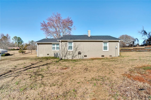 rear view of house with crawl space, a lawn, central AC unit, and brick siding