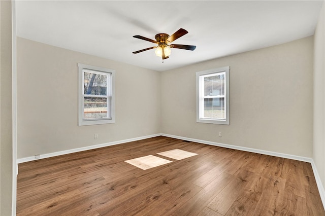 spare room with baseboards, ceiling fan, and hardwood / wood-style floors