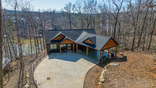 rustic home featuring driveway and a forest view