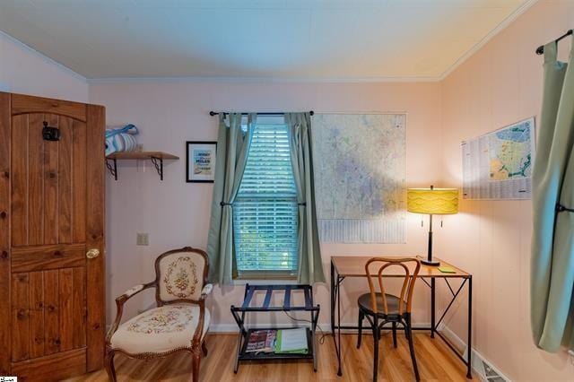 living area with crown molding and wood finished floors