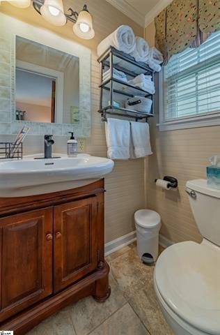 bathroom with toilet, ornamental molding, vanity, and tile patterned flooring