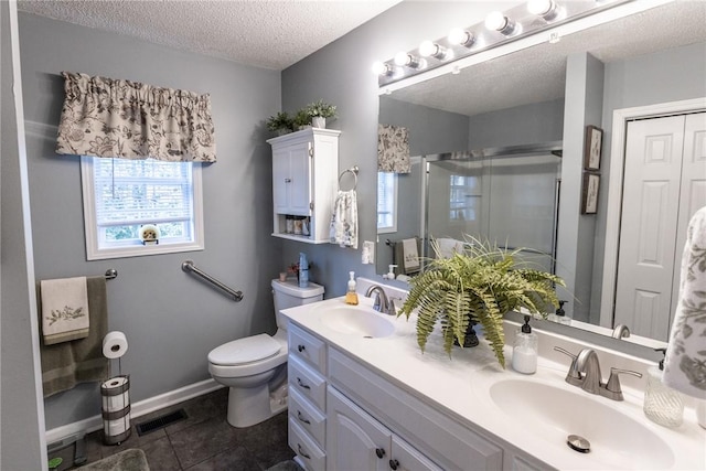 full bath with visible vents, a stall shower, a textured ceiling, and a sink