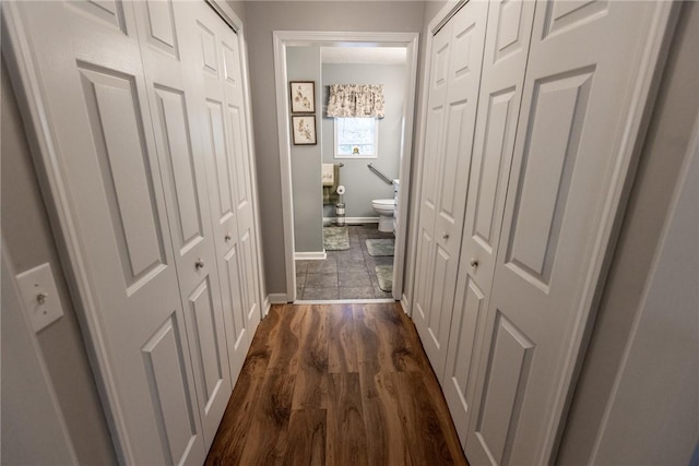 hall with baseboards and dark wood-style flooring