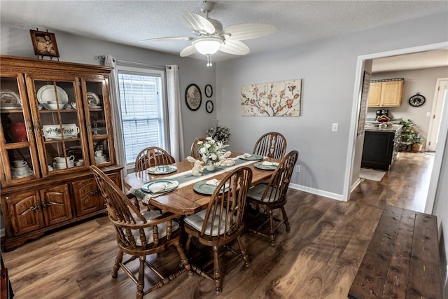 dining area with baseboards, a textured ceiling, dark wood finished floors, and a ceiling fan