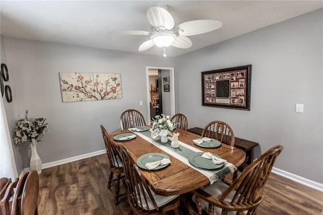 dining space featuring a ceiling fan, dark wood-type flooring, and baseboards