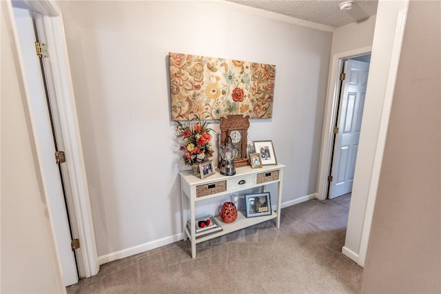 hallway with baseboards, a textured ceiling, and carpet