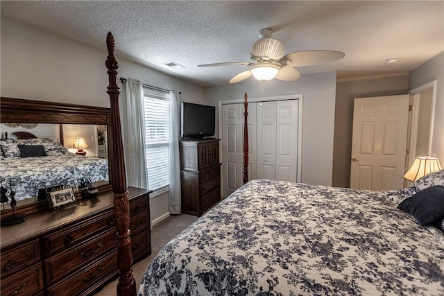 bedroom featuring a ceiling fan, visible vents, carpet floors, a closet, and a textured ceiling