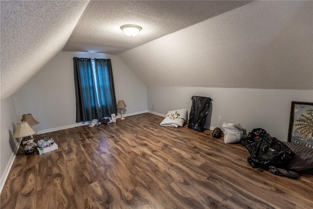 bonus room featuring baseboards, a textured ceiling, wood finished floors, and vaulted ceiling