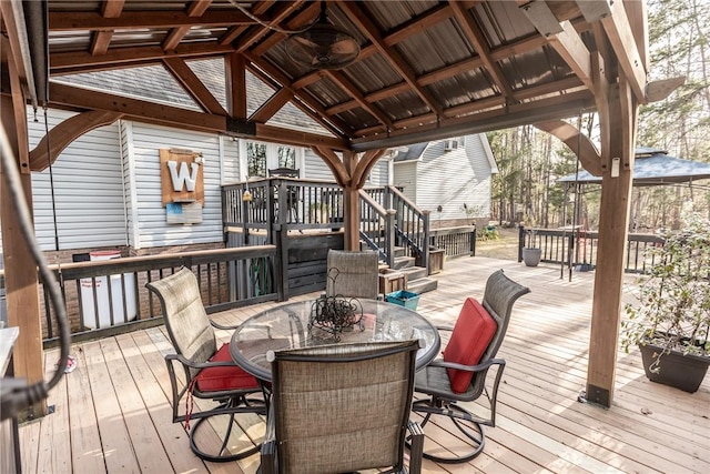 wooden terrace featuring a gazebo and outdoor dining area