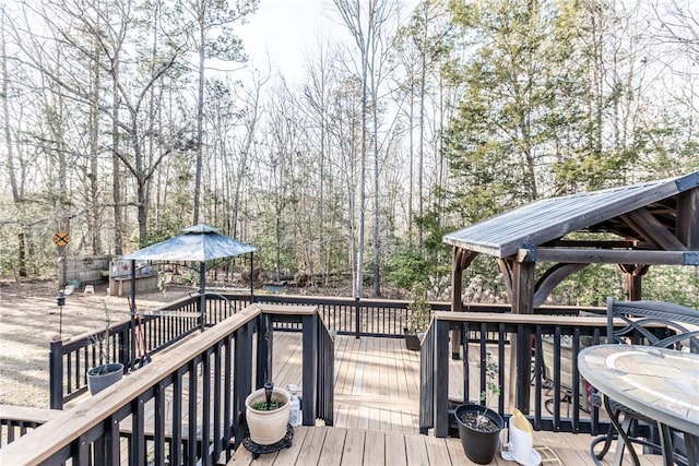 wooden deck with a gazebo and outdoor dining area