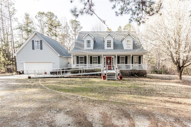 cape cod home featuring an attached garage, covered porch, driveway, and roof with shingles