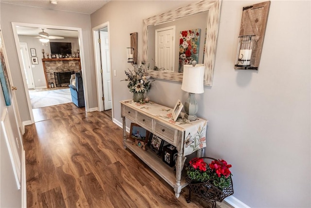 corridor featuring baseboards and wood finished floors