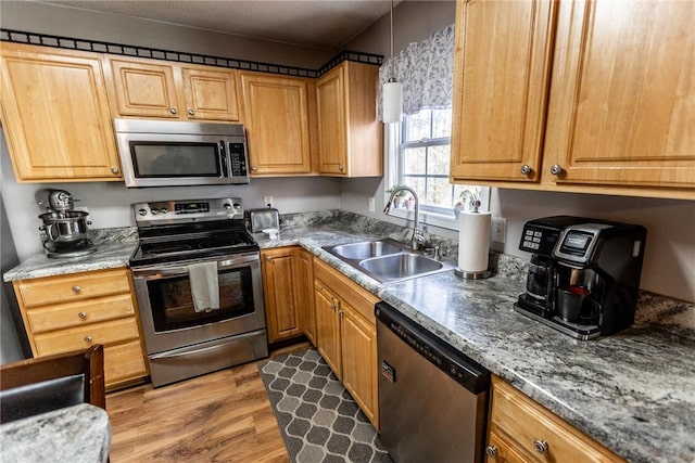 kitchen with a sink, stainless steel appliances, and light wood-style floors