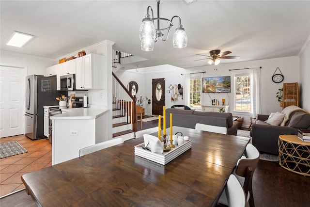 dining room with ornamental molding, stairway, light tile patterned floors, and ceiling fan