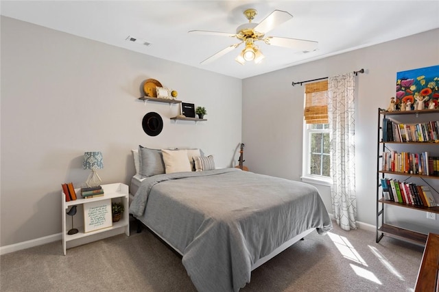 carpeted bedroom with visible vents, a ceiling fan, and baseboards