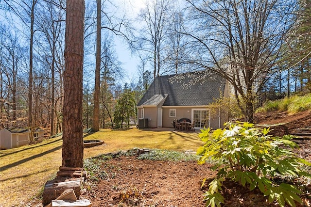 view of yard featuring an outbuilding, central air condition unit, a patio area, and a shed