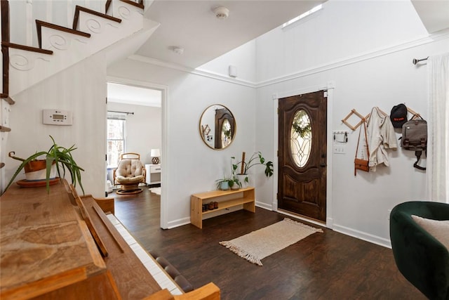 foyer with baseboards, lofted ceiling, and wood finished floors