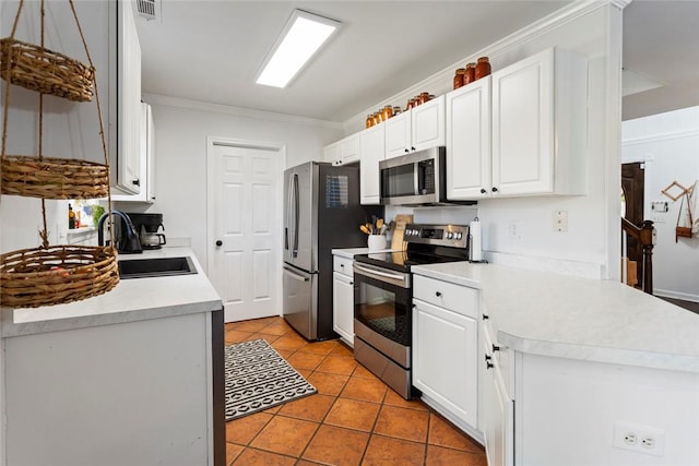 kitchen featuring light tile patterned flooring, a sink, stainless steel appliances, light countertops, and white cabinets