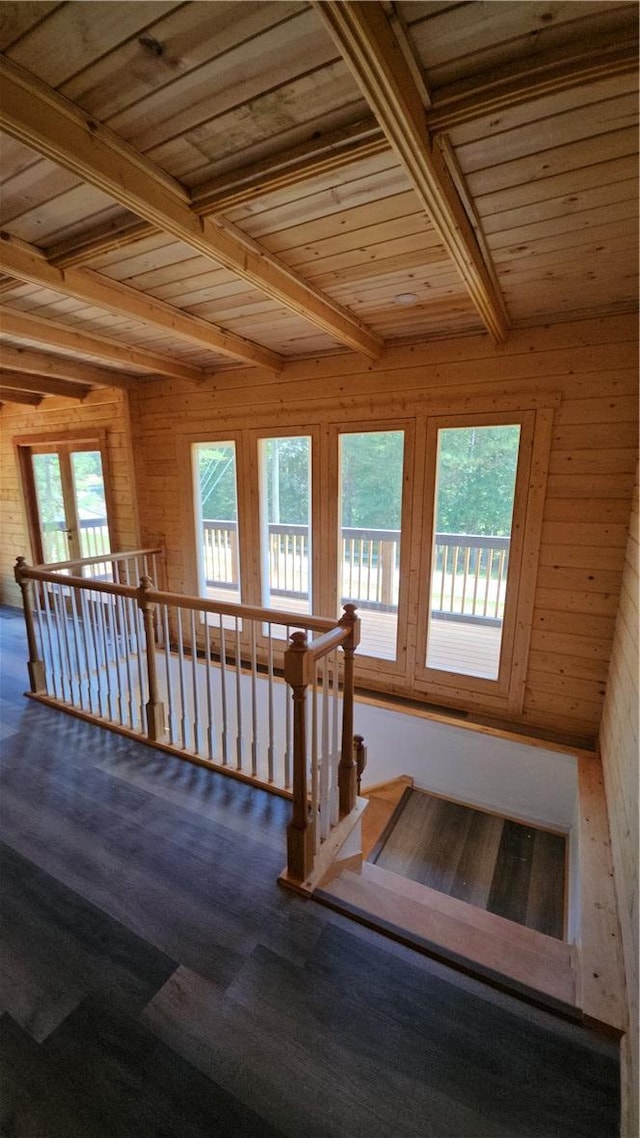 staircase featuring beamed ceiling, wooden walls, wood ceiling, and carpet flooring