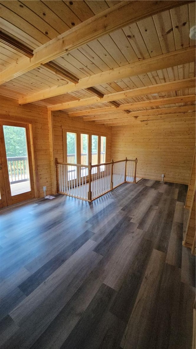 additional living space with beamed ceiling, wood ceiling, wood finished floors, and wood walls