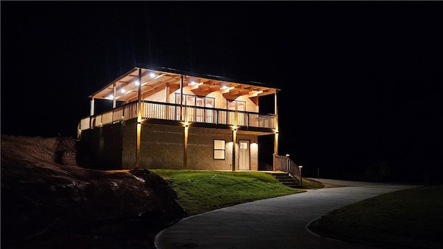 property exterior at night featuring a yard