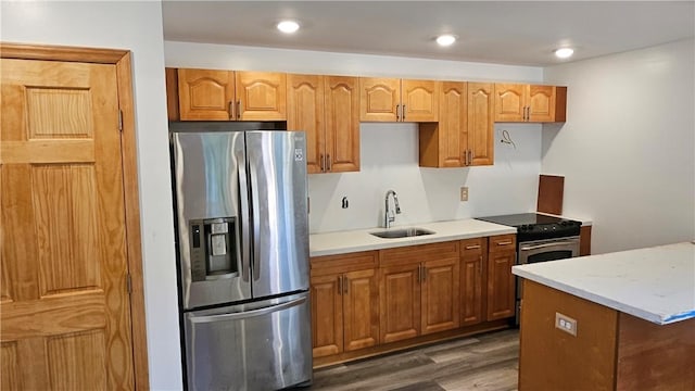 kitchen with dark wood finished floors, recessed lighting, appliances with stainless steel finishes, and a sink