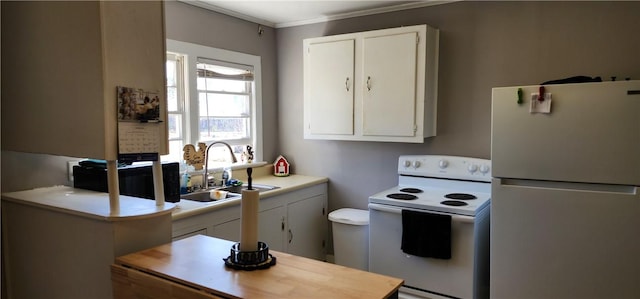 kitchen featuring white appliances, white cabinetry, and a sink