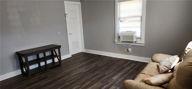 living area featuring dark wood-style floors, cooling unit, and baseboards