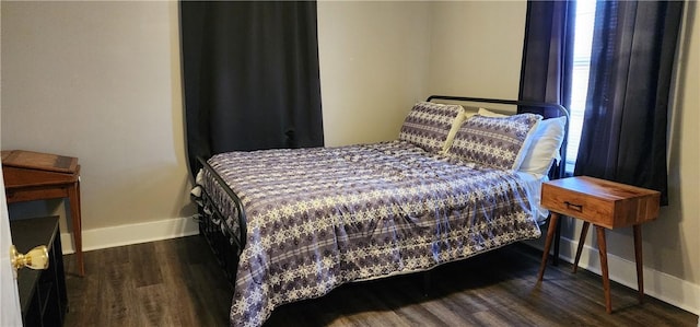 bedroom featuring wood finished floors and baseboards