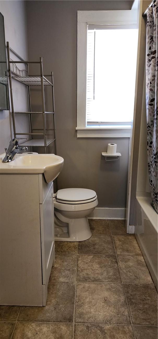 full bathroom featuring vanity, toilet, shower / bath combo, and baseboards