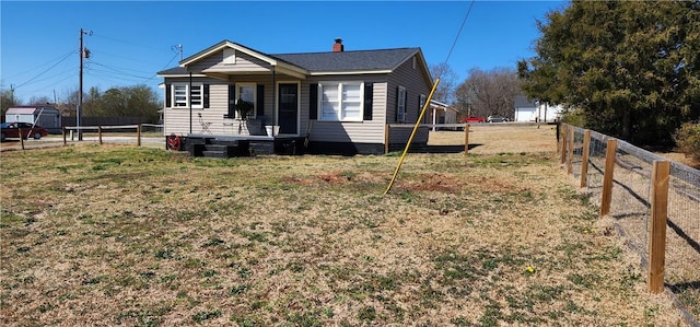 view of front facade featuring a front yard and fence