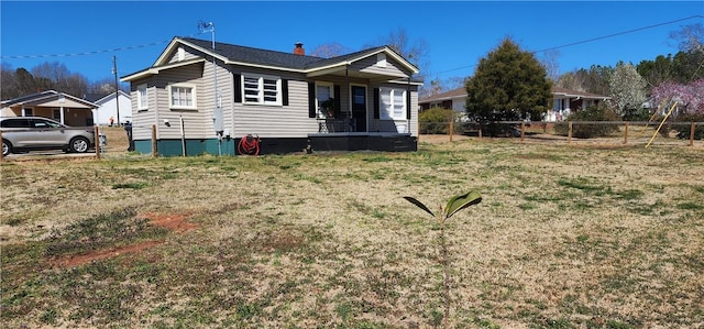 back of property with fence and a lawn