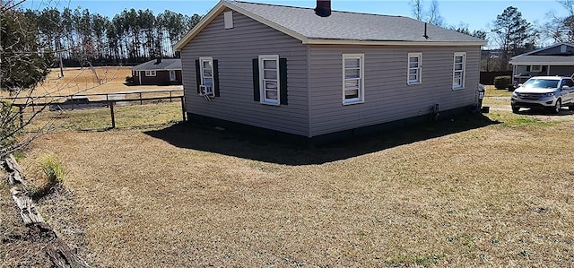 view of side of property featuring cooling unit, a chimney, and fence