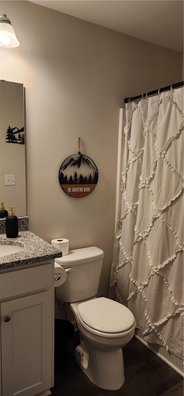 full bathroom with a shower with curtain, toilet, wood finished floors, and vanity