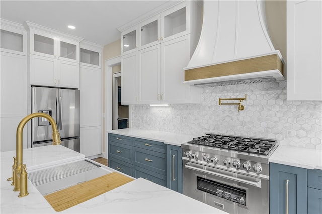 kitchen featuring white cabinets, premium range hood, and stainless steel appliances