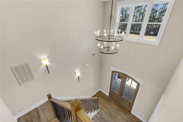 entryway featuring visible vents, plenty of natural light, a notable chandelier, and wood finished floors