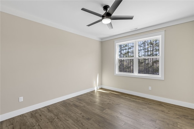 spare room featuring dark wood finished floors, baseboards, visible vents, and ceiling fan