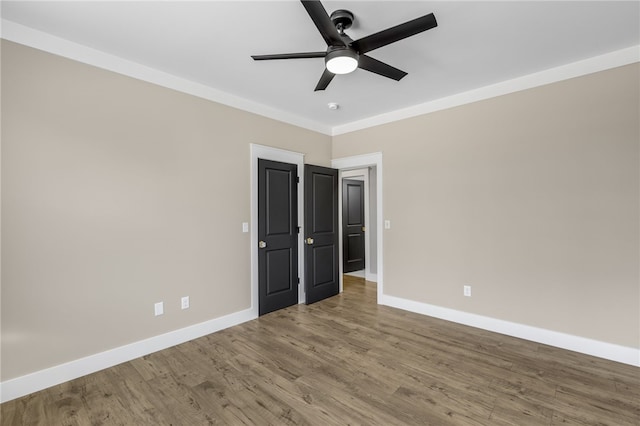 unfurnished bedroom with wood finished floors, baseboards, and ceiling fan