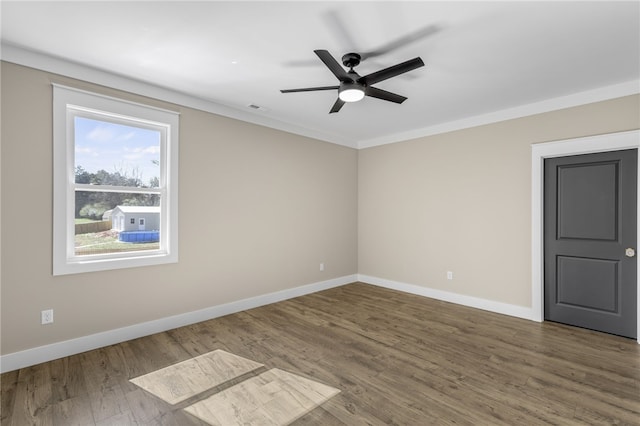 empty room featuring a ceiling fan, crown molding, baseboards, and wood finished floors