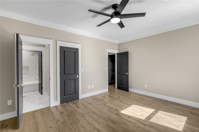 unfurnished bedroom featuring light wood finished floors, connected bathroom, baseboards, and ceiling fan