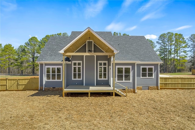 back of property featuring a deck, a ceiling fan, fence, and roof with shingles