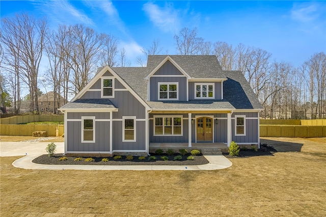 craftsman-style house with fence, french doors, covered porch, board and batten siding, and a front yard