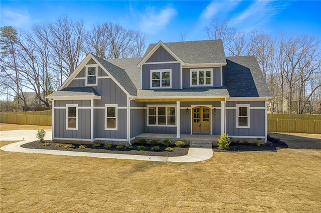 craftsman-style house with french doors, board and batten siding, a front lawn, and fence