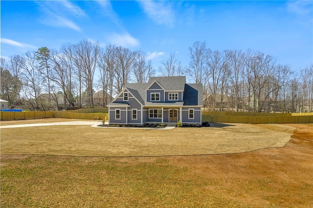 view of front of property featuring a front yard, fence, and driveway