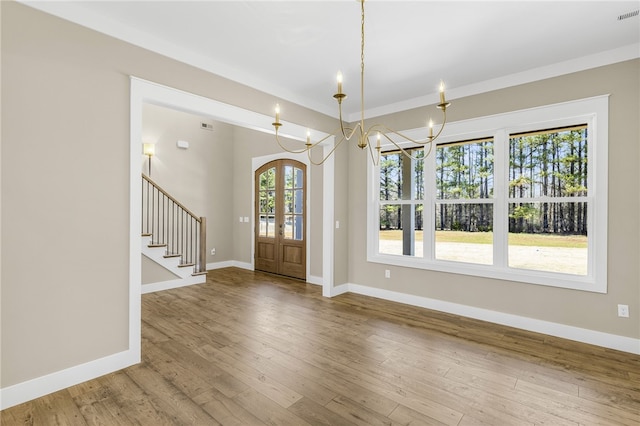 foyer with a chandelier, stairway, baseboards, and wood finished floors