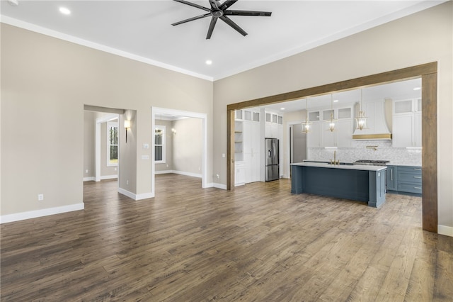 unfurnished living room with baseboards, ceiling fan, and dark wood-style flooring