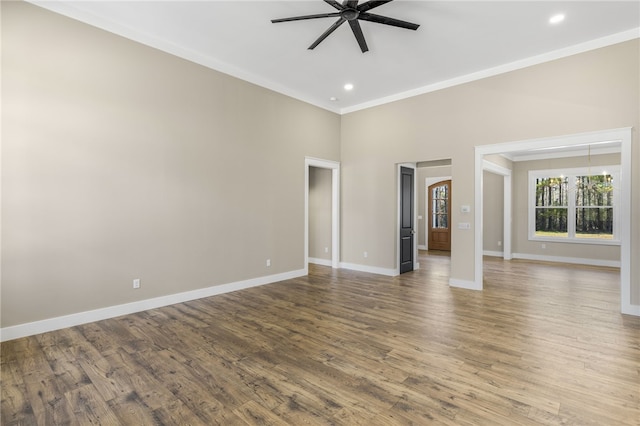 unfurnished room with wood finished floors, baseboards, ceiling fan, and crown molding