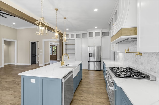 kitchen with custom exhaust hood, a sink, stainless steel appliances, white cabinetry, and blue cabinets